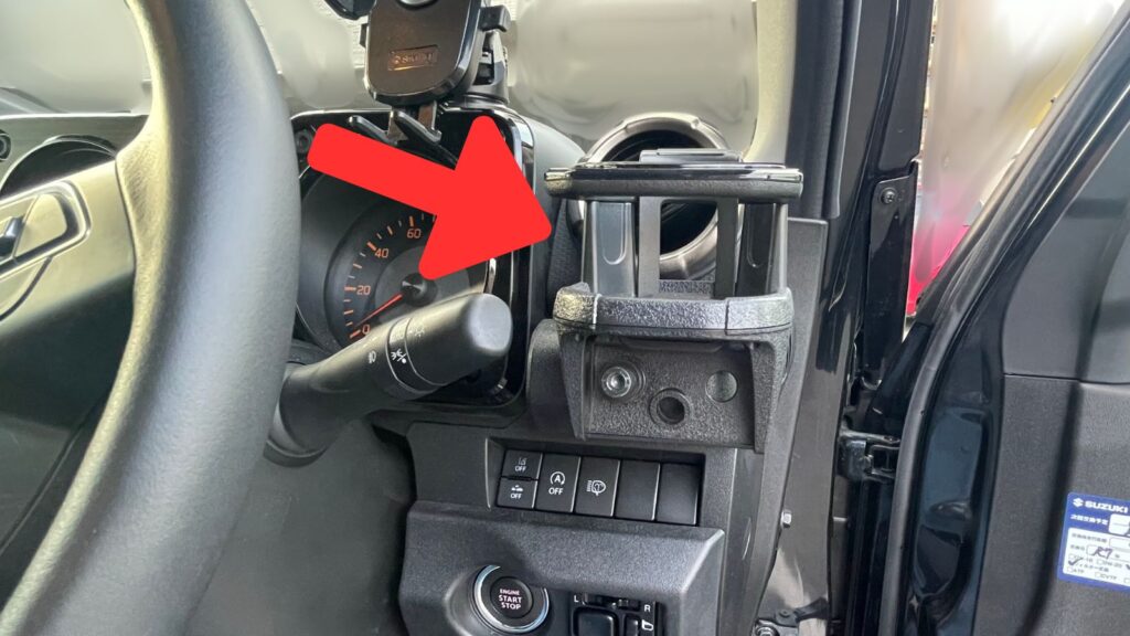 ジムニーの運転席側コンソールに安定設置されたドリンクホルダー。エアコン吹き出し口ではなく直下の樹脂パネルに装着されている。