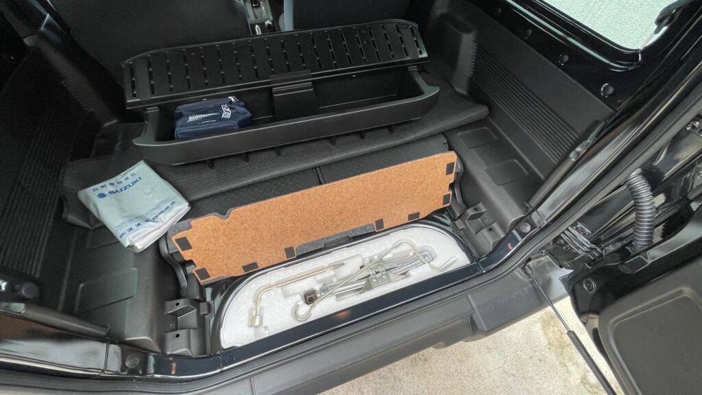 ジムニーJB64の荷室に収納された純正ジャッキと車載工具一式の様子
