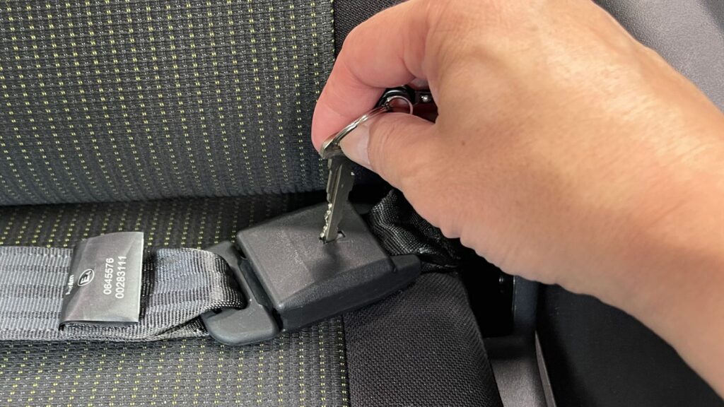 ジムニー後部座席の鍵穴付きバックルに車の金属キーをまっすぐ差し込んで解除する手順