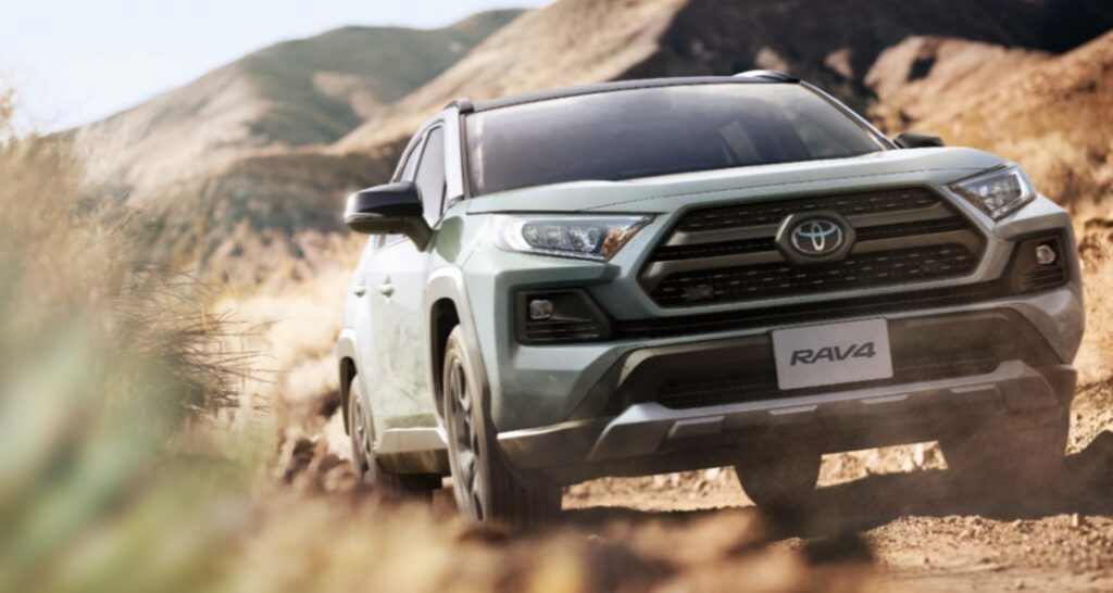 後部座席が広く実用的なおすすめSUV、トヨタRAV4。オフロードを力強く走行している様子。