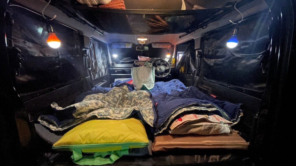 ジムニーJB64の車内をフルフラットにして夫婦2人で車中泊をする寝床の様子。左側が173cmの夫、右側が164cmの妻が寝るスペース。
